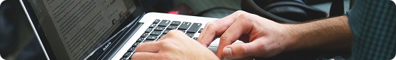 Hands typing on a laptop