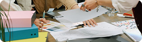 Hands reviewing printed designs